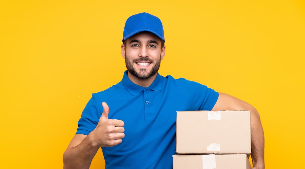 Entregador dos Correios carregando encomendas em caixas de papelão, compradas com a funcionalidade de correios barato da Frenet
